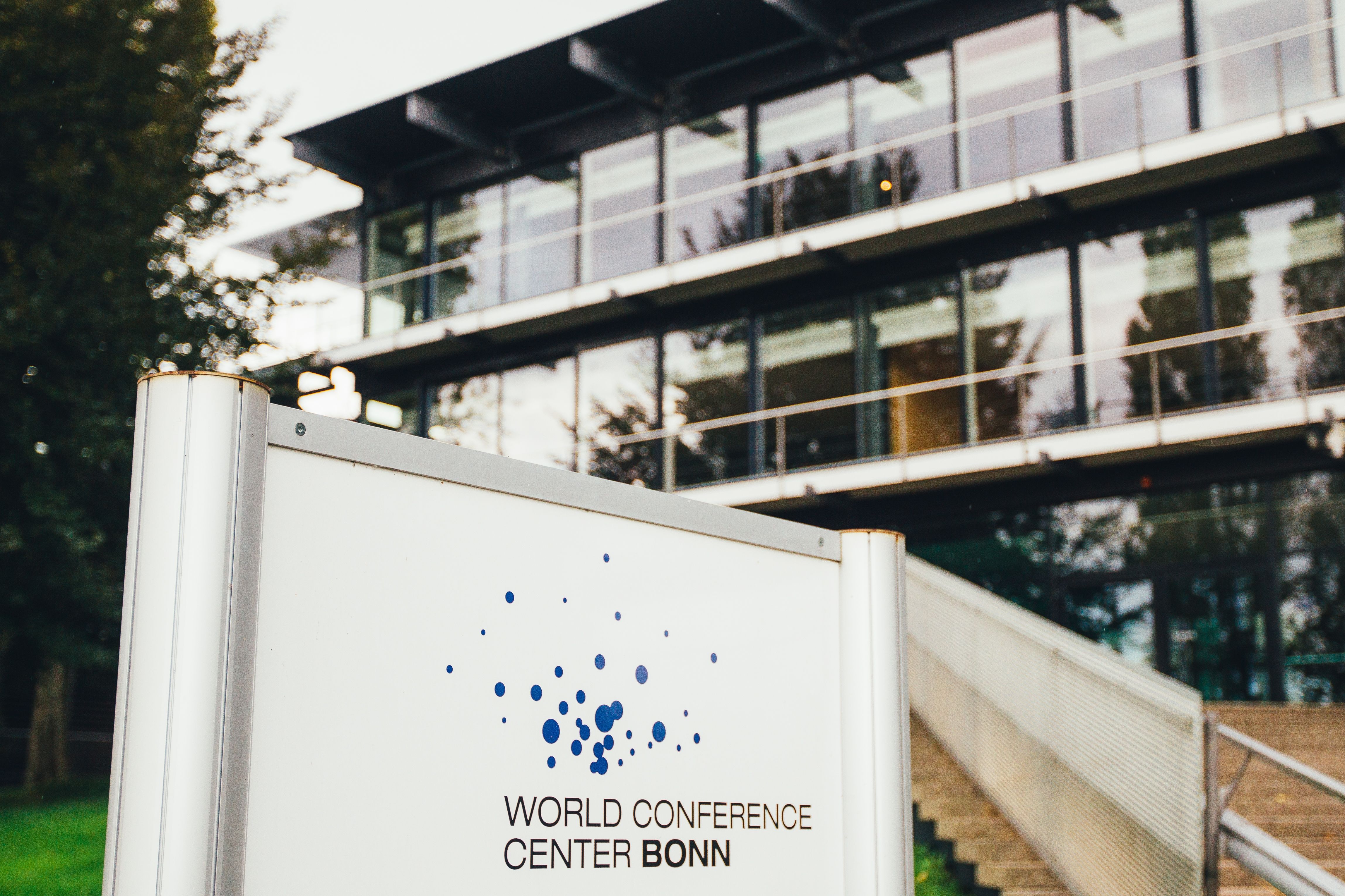 Eingang des World Conference Center Bonn mit einem Schild im Vordergrund.