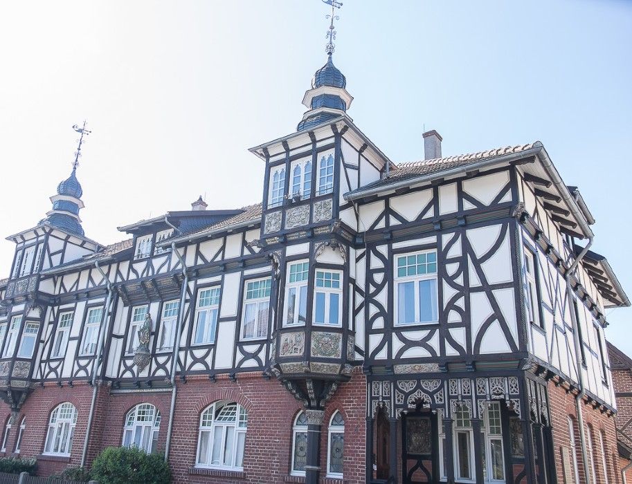 Fachwerkhaus in Rheda-Wiedenbrück mit verzierten Fassaden und Türmen.