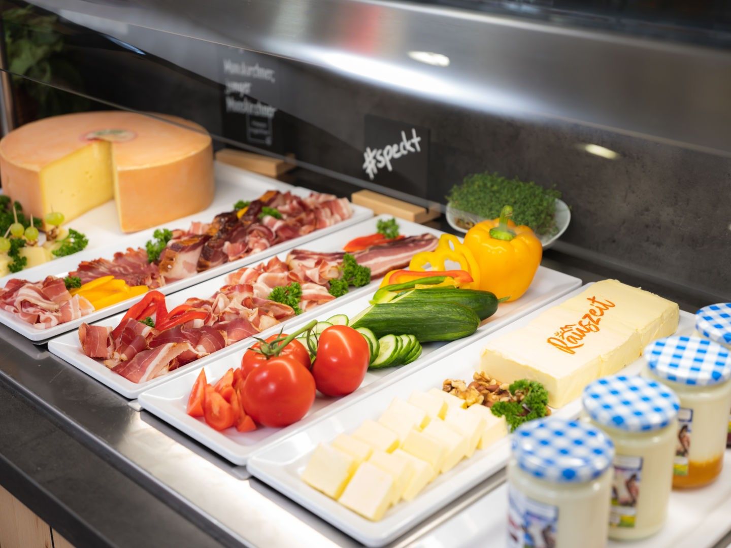 Frühstücksbuffet mit Käse, Aufschnitt, Gemüse und Joghurt im JUFA Hotel.