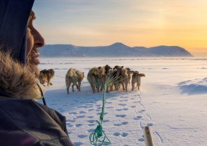 Die Ausstellung gibt Einblicke in eine fremde Kultur: Auf einem Bild ist ein Jaeger mit Hundeschlitten auf dem Eis der Melville Bay bei Kullorsuaq zu sehen, © Martin Zwick