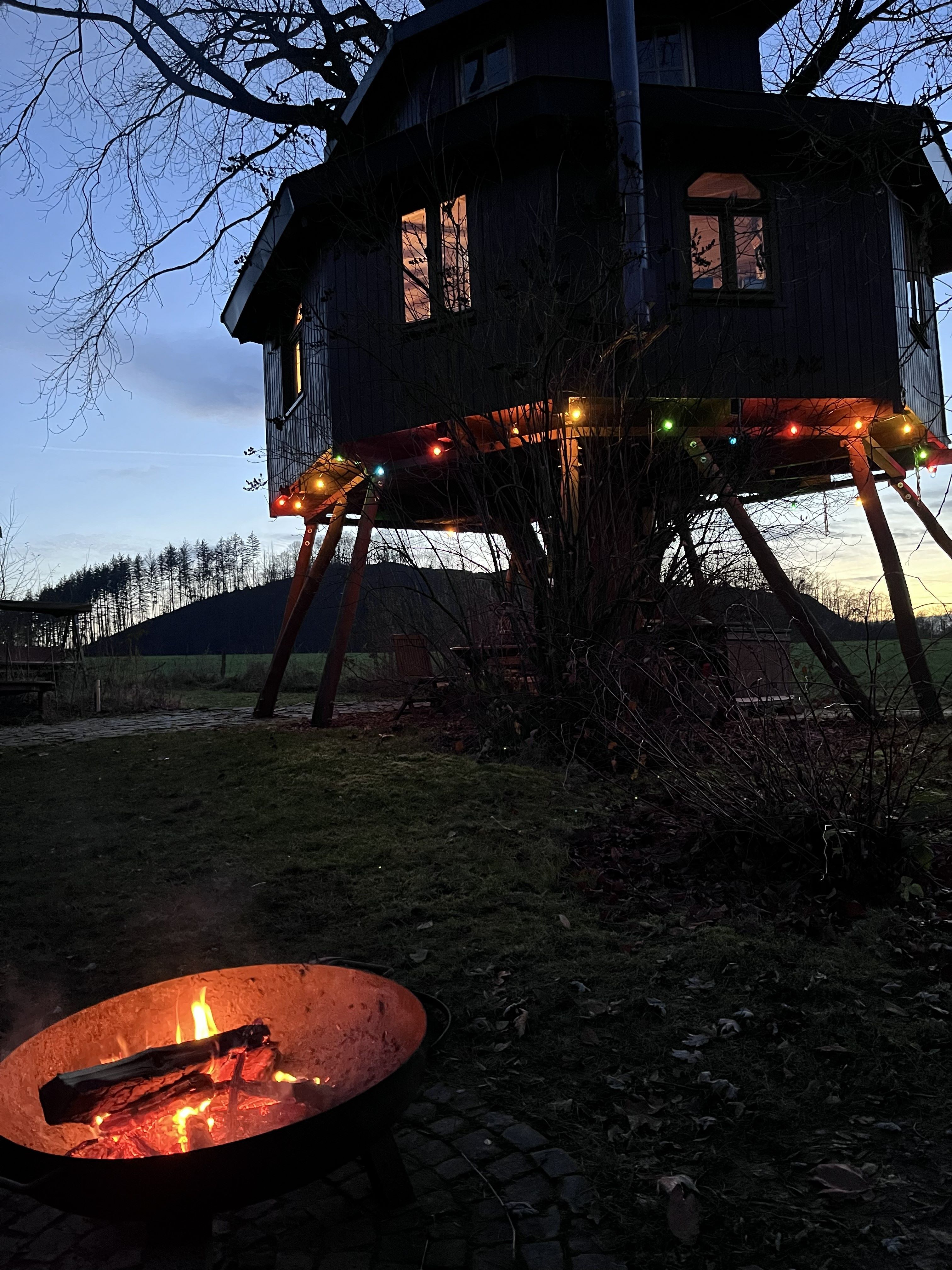 Siegtal-Baumhaus am Abend mit Feuerschale