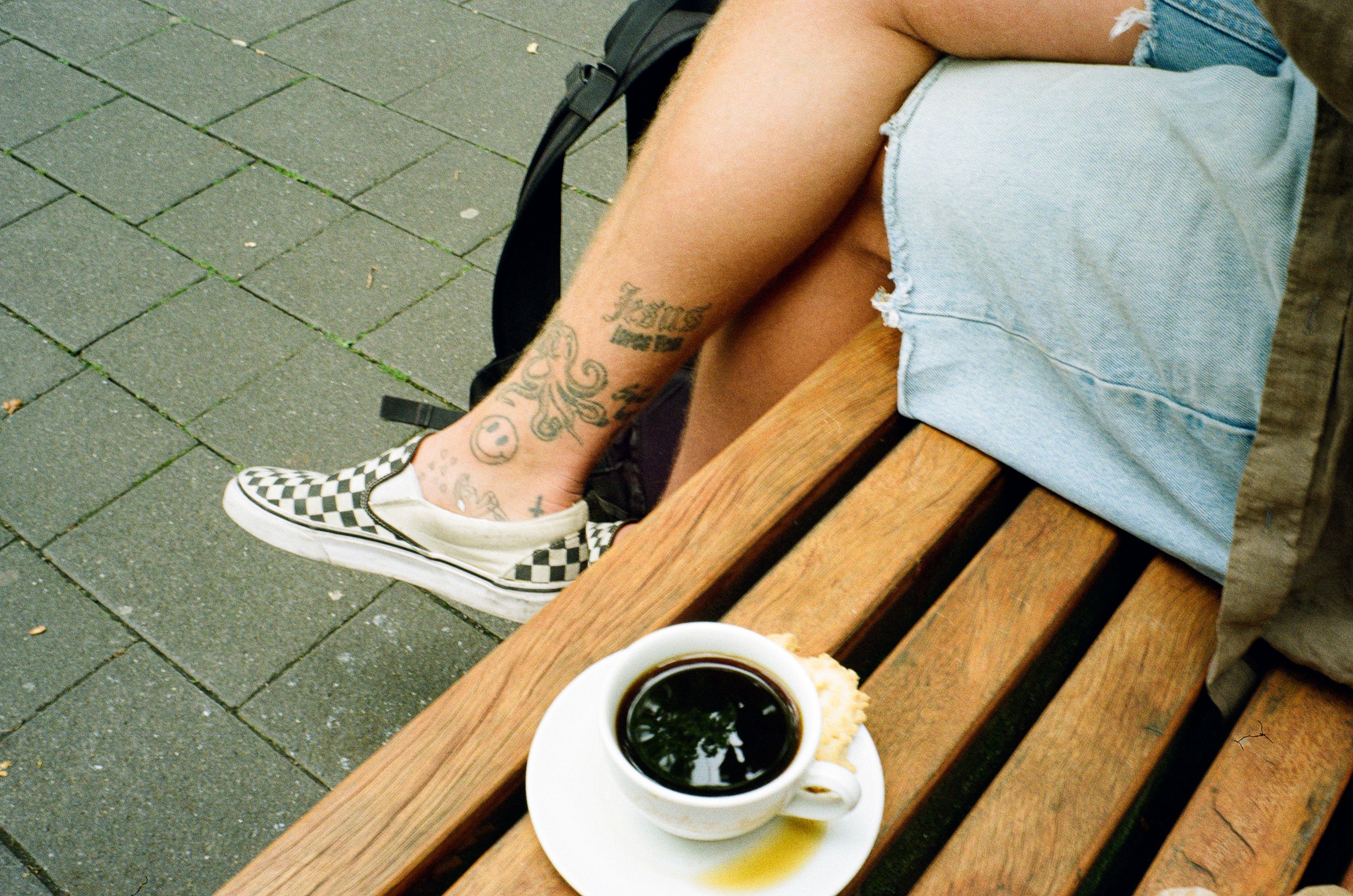 Sitzender Mann mit Kaffee auf einer Parkbank auf dem Ruhrtalradweg im Ruhrgebiet.