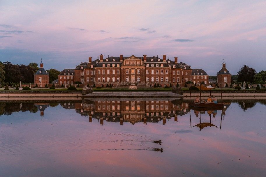 Schloss im Abendlicht spiegelt sich im Wassergraben