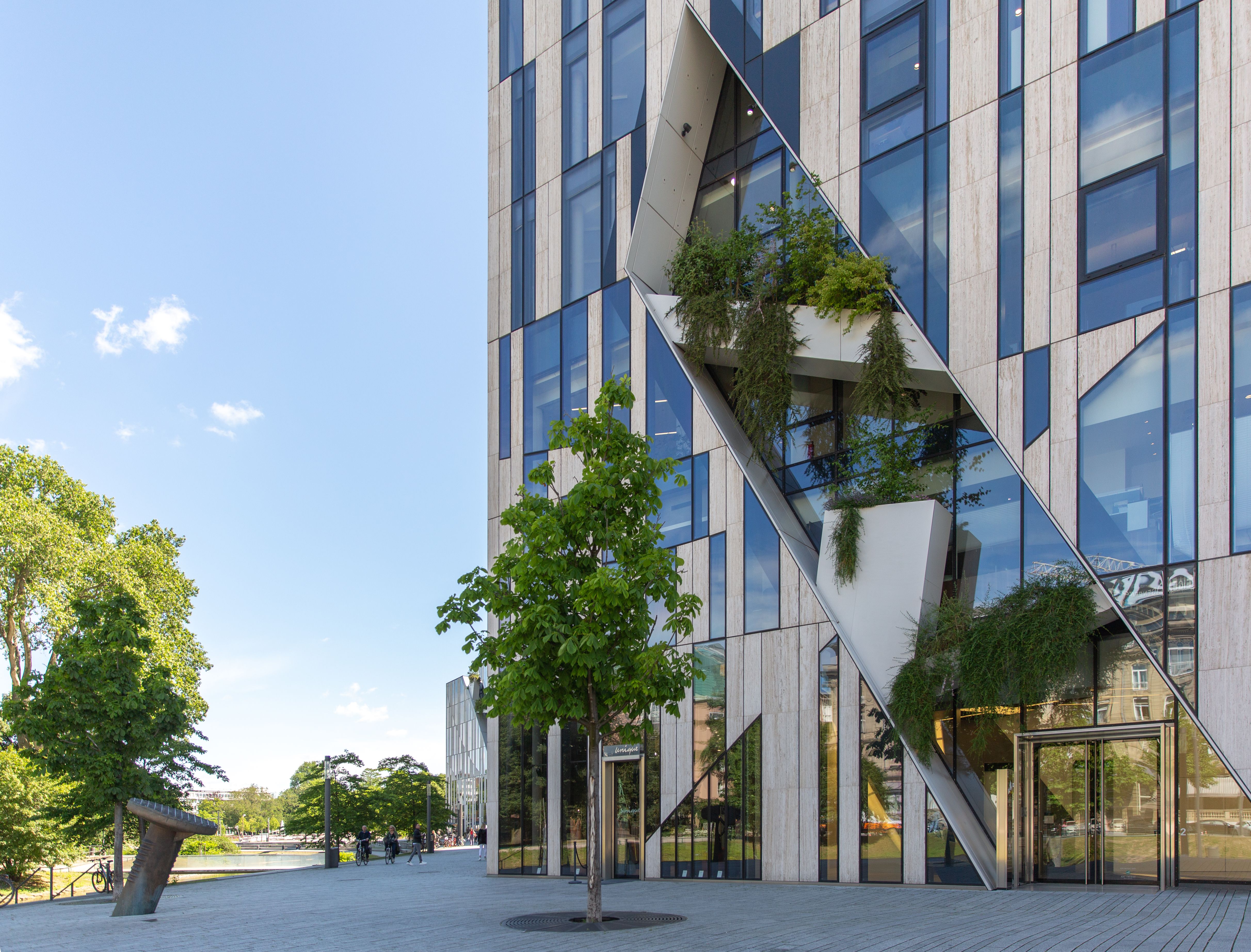 Moderne Architektur des Kö-Bogens in Düsseldorf mit Glasfassade und integrierten Pflanzen.