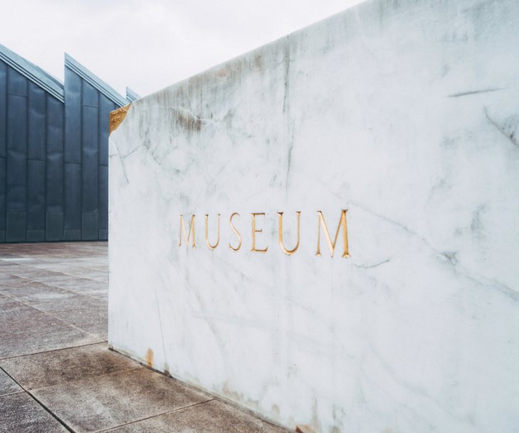 Ein goldener Schriftzug auf weißem Marmor kennzeichnet den Weg zum Eingang des Museums Abteiberg, © Johannes Höhn