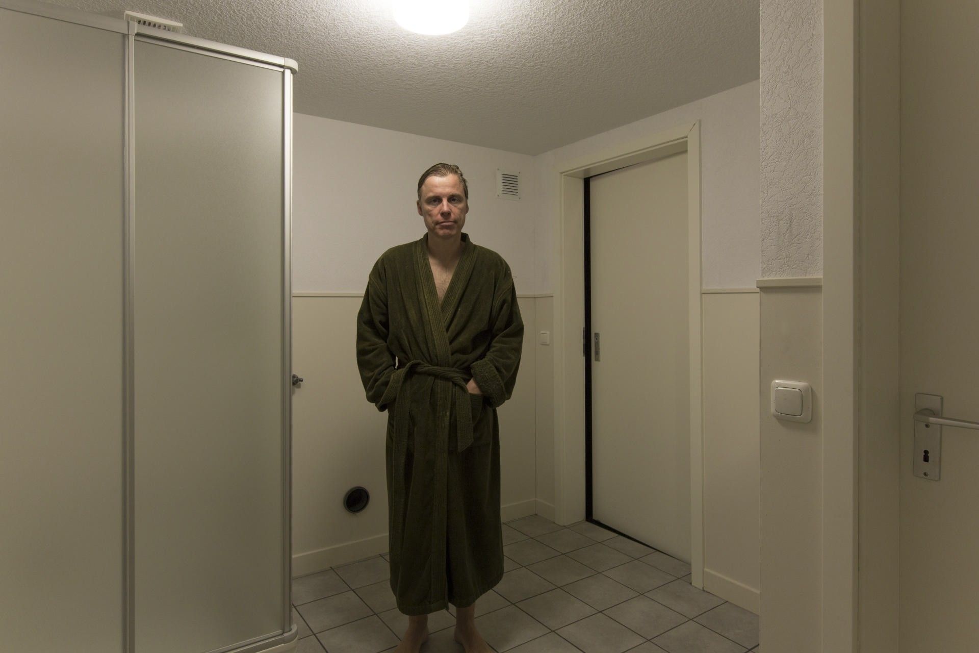 Selbstportrait in der beklemmenden Atmosphäre eines sterilen Badezimmers aus dem Projekt "Neuburgerstraße 21" in einer  alten Industriehalle des Schauspiels Köln