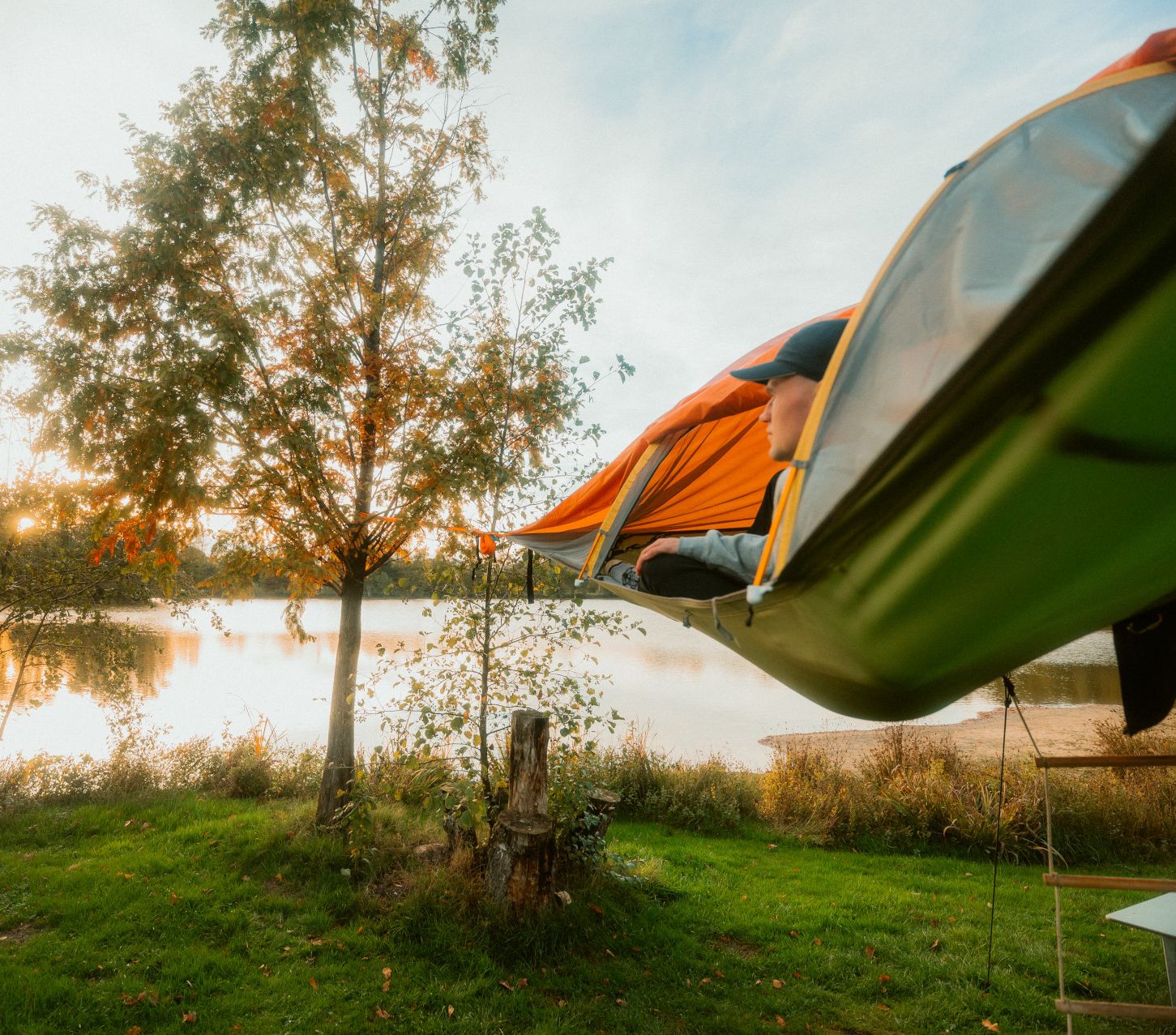 Person im Schwebezelt blickt auf See des Campingplatzes Dingdener Heide