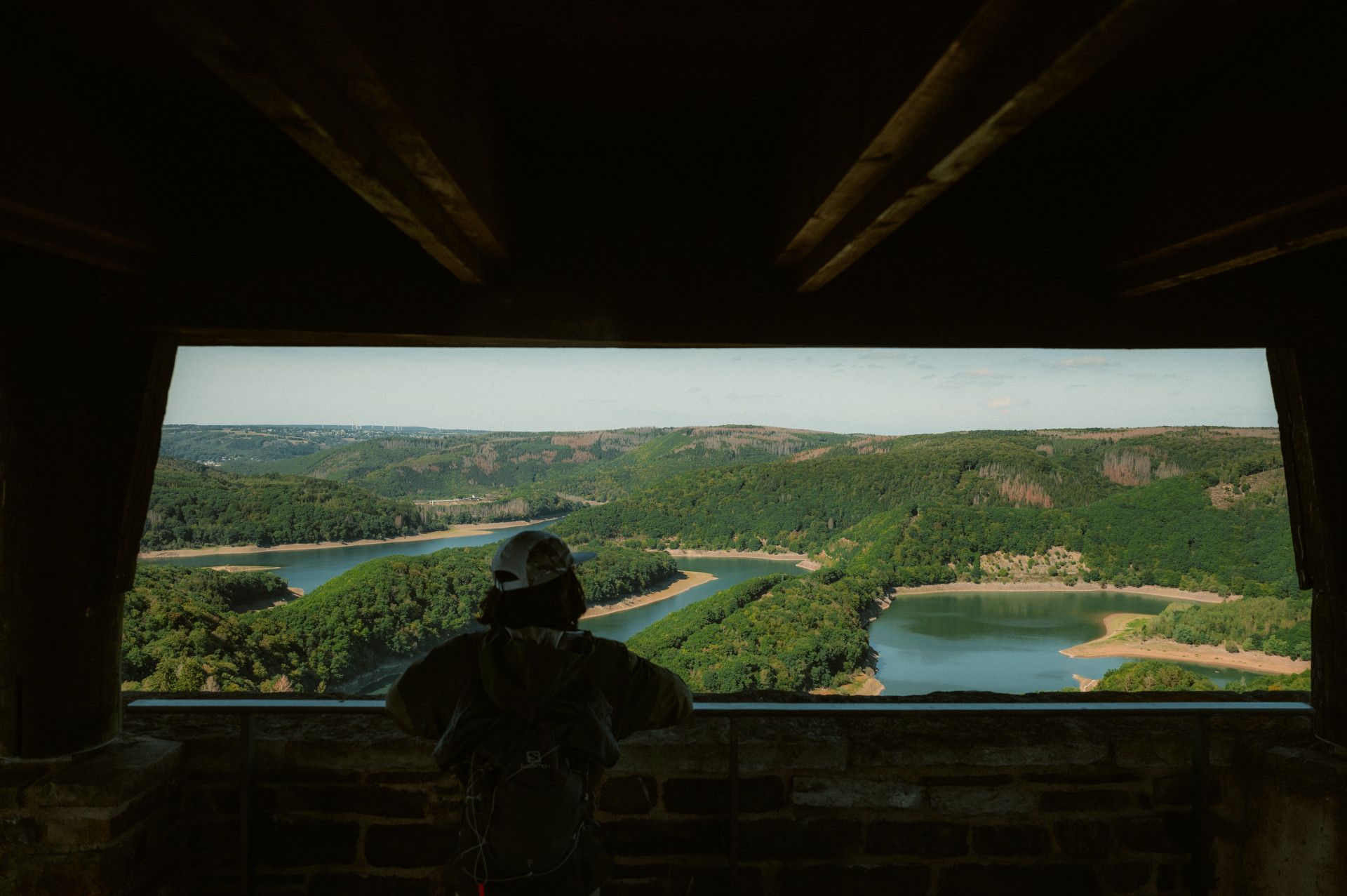 Person blickt von einem Aussichtspunkt auf die Urfttalsperre in der Eifel.