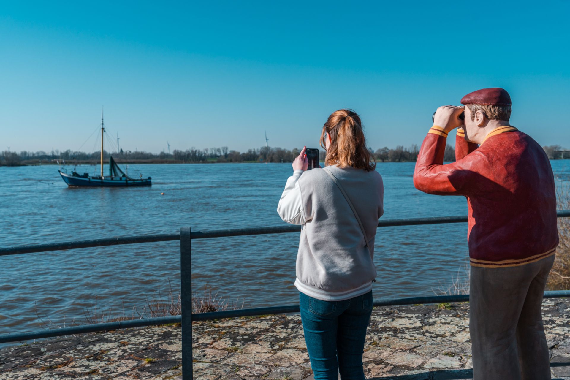 Am Rhein bei Rees können Reisende Schiffe auf dem Wasser beobachten