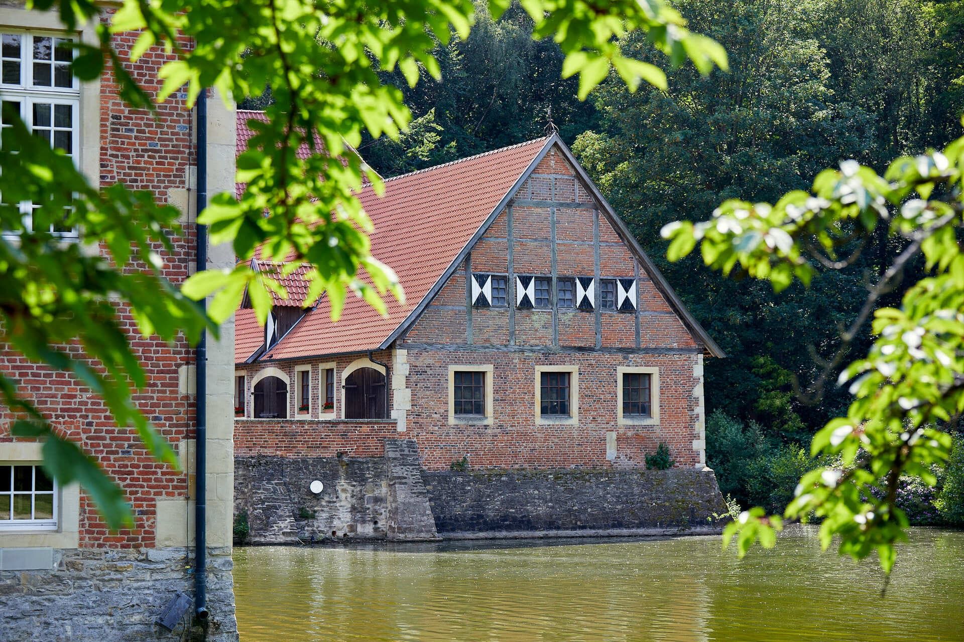 Blick durch die Bäume auf Burg Hülshoff im Münsterland