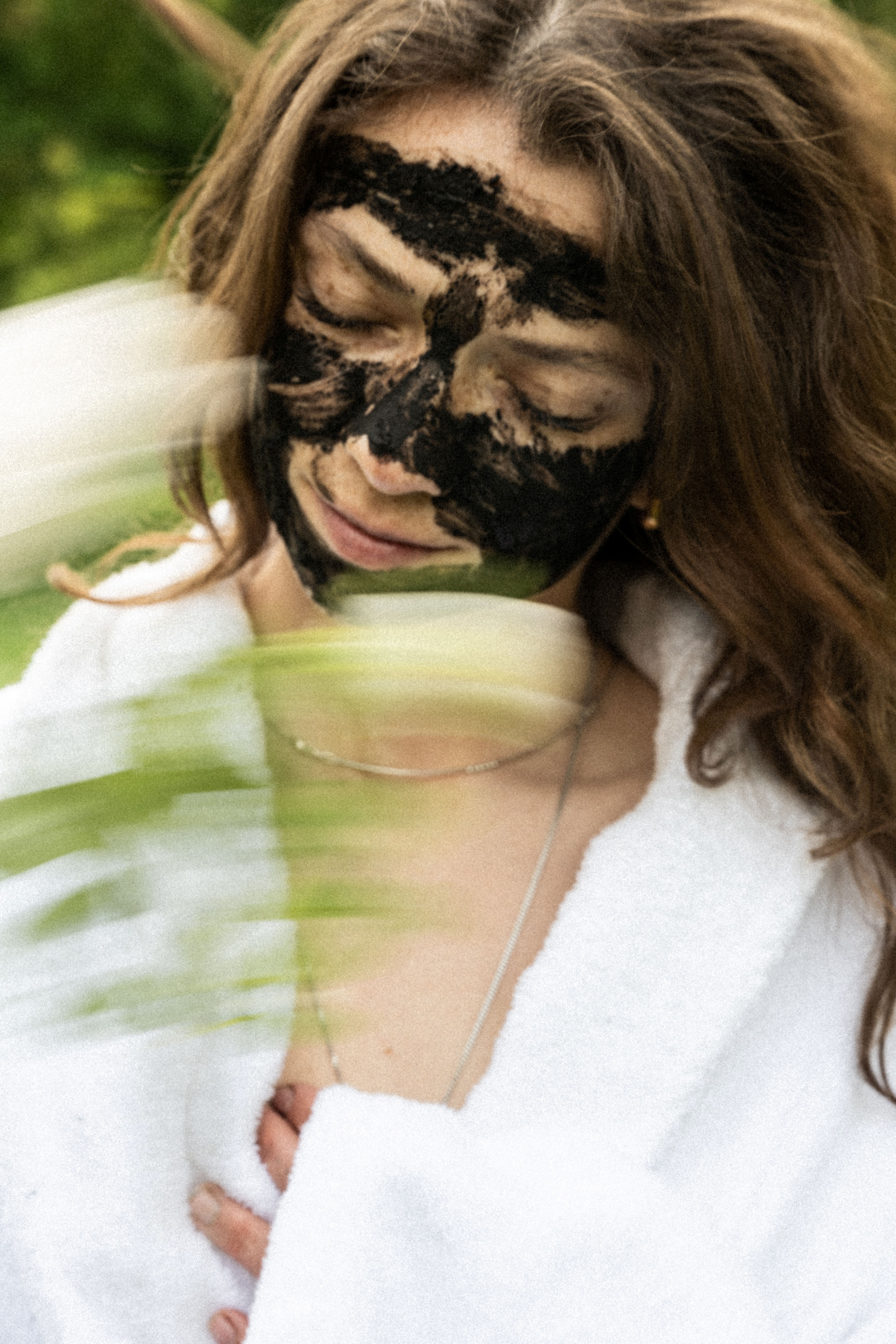 Eine Frau in einem weißen Kleid mit einer Moormaske im Gesicht in Bad Driburg.