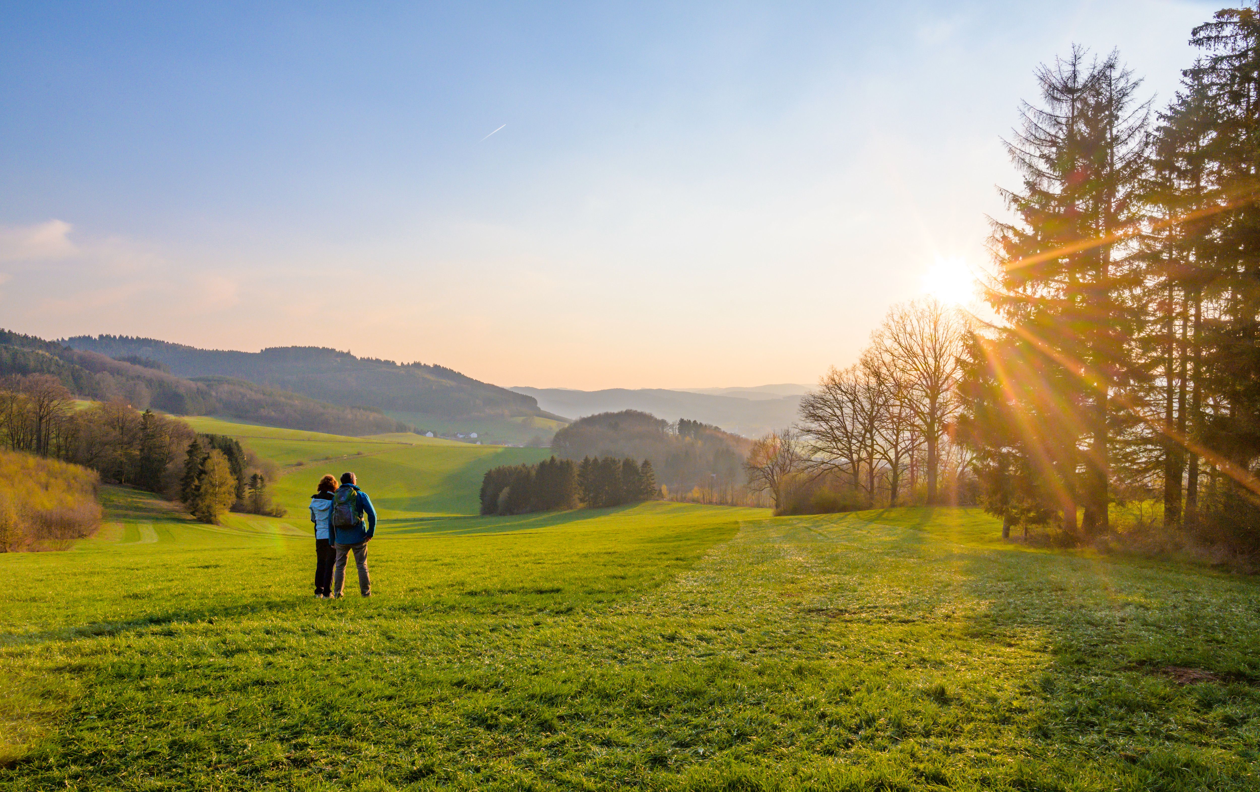 Zwei Personen schauen in den Sonnenuntergang im Sauerland.