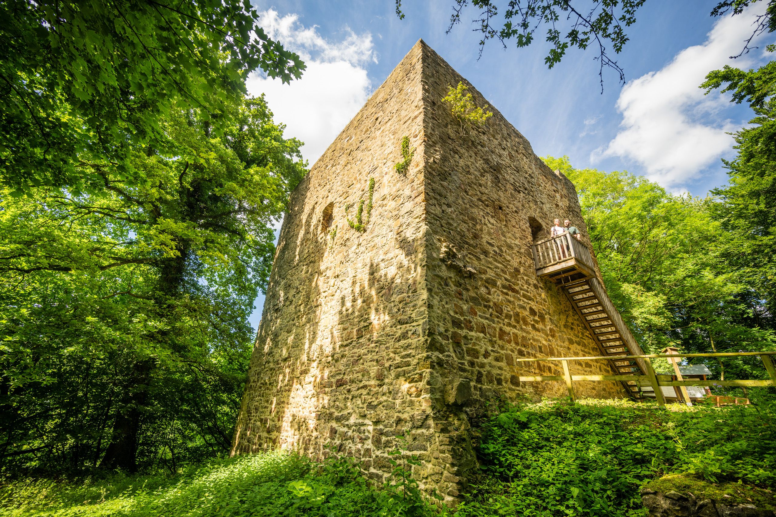Turm umgeben von Bäumen und mit einer Holztreppe an der Seite.