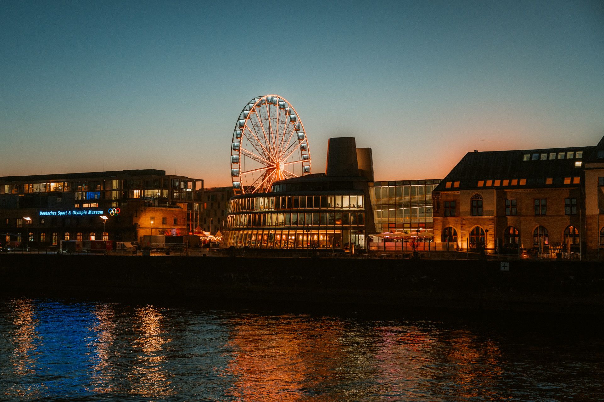 Abendliche Ansicht des Schokoladenmuseums und Riesenrads in Köln am Rhein.