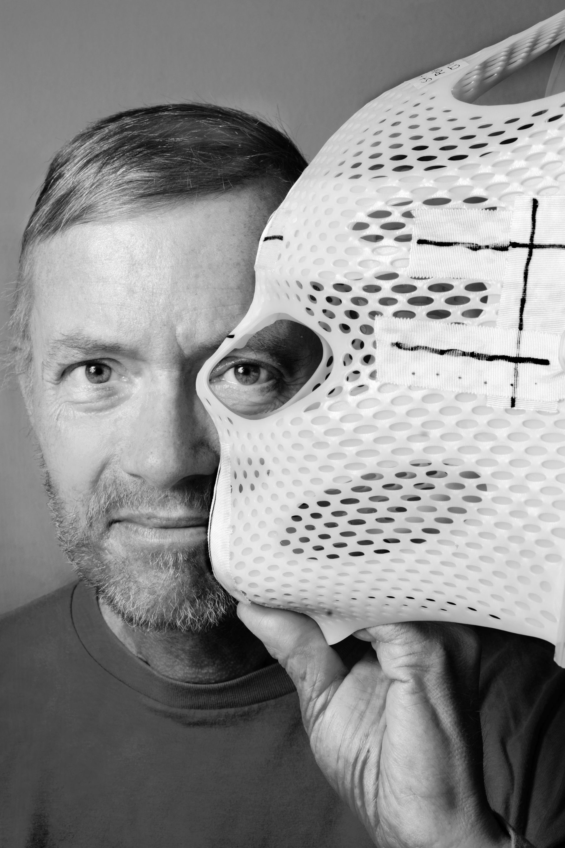 Herlinde Koelbls Porträt zeigt einen Patienten mit seiner maßgefertigten Thermoplastmaske. Die darauf gezeichneten Fadenkreuze dienen bei der Strahlentherapie als überlebenswichtiger Wegweiser für die millimetergenaue Behandlung